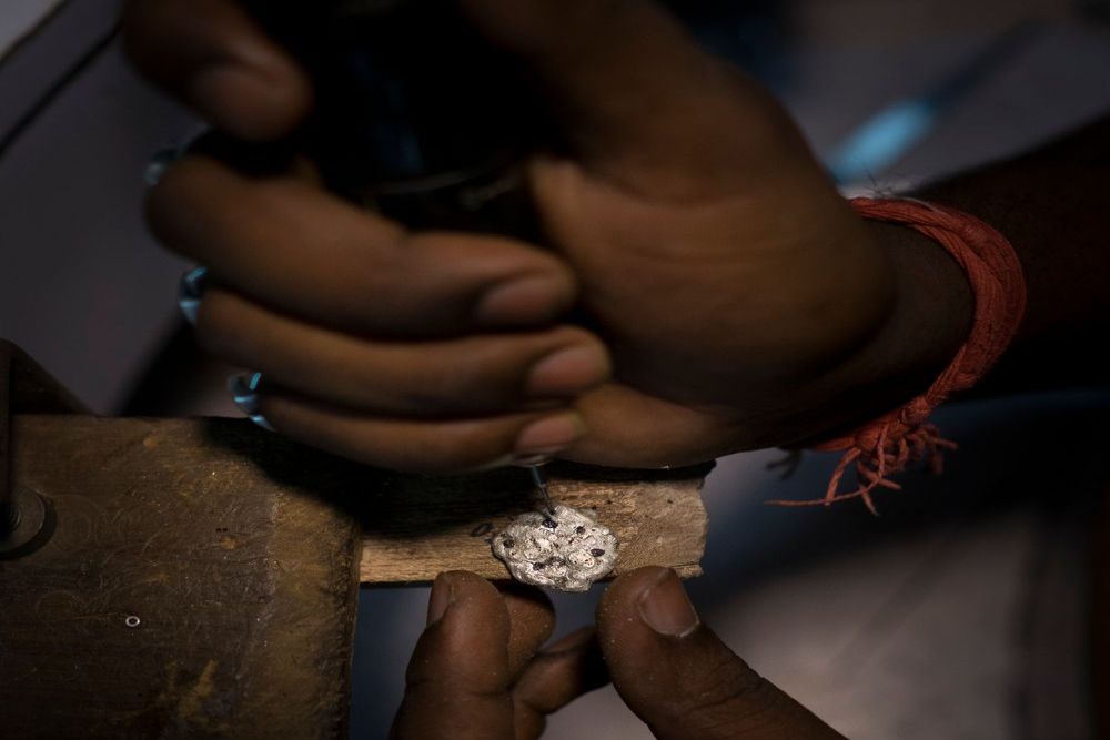 image of jeweller setting gemstone in jewellery