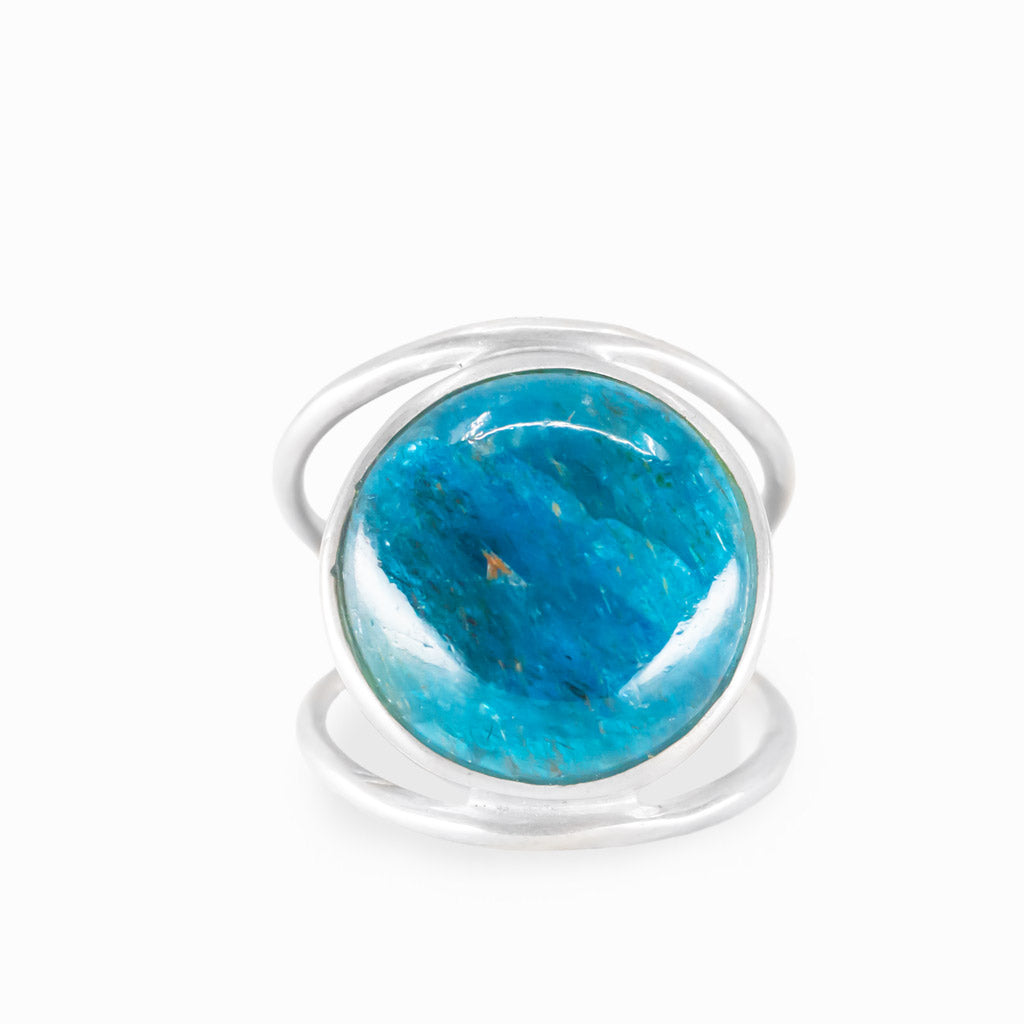 Round Blue Apatite ring with vivid turquoise-blue cabochon, natural inclusions, polished sterling silver bezel, and openwork band.