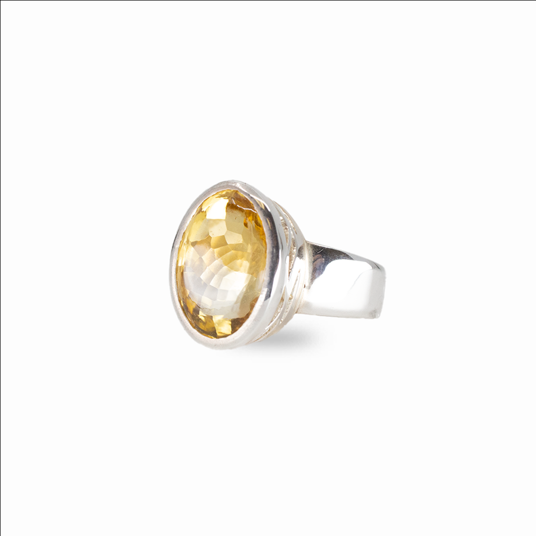 Faceted oval citrine gemstone ring set in sterling silver on white background