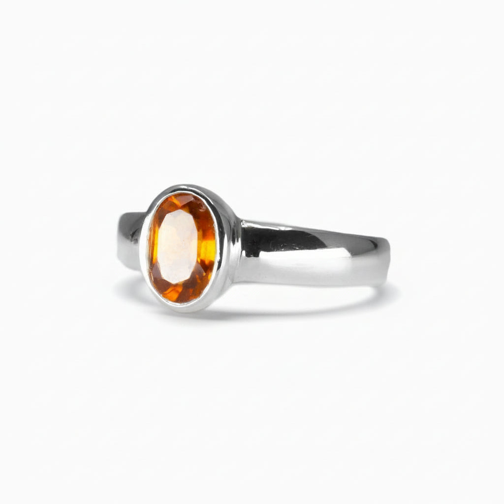 Oval faceted Hessonite Garnet ring in sterling silver with warm orange-amber tones on a white background | MADE IN EARTH