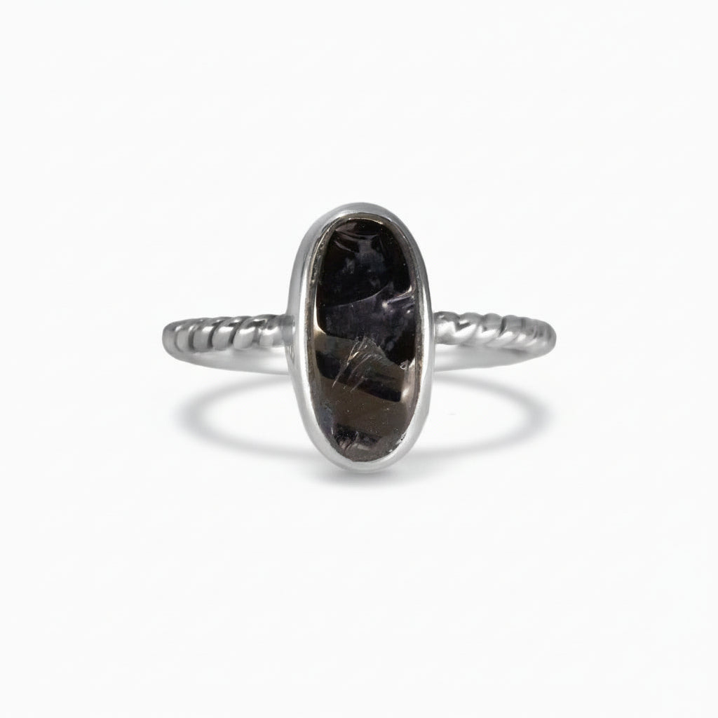 Oval polished Shungite ring set in a sterling silver textured band, featuring deep black reflective tones on a white background. | MADE IN EARTH