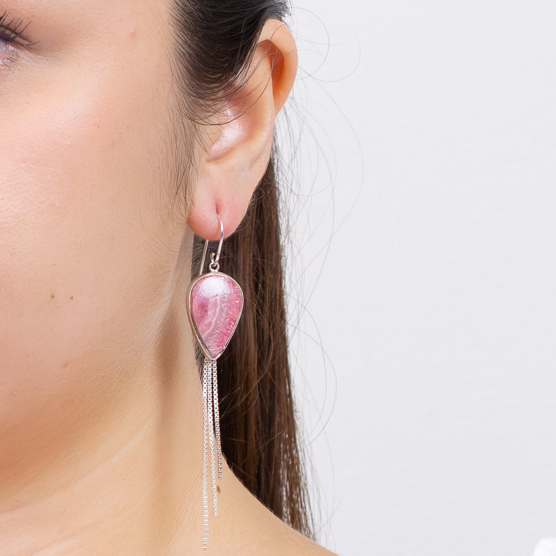 Rhodochrosite teardrop earrings in sterling silver with cascading chain-fringe and pink banded gemstone on model. | MADE IN EARTH