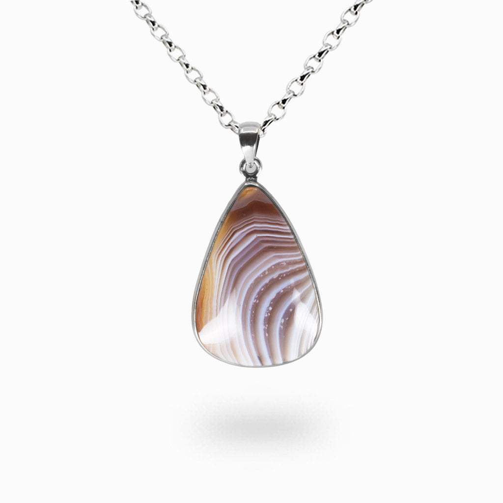 Tear-shaped Botswana Agate pendant with natural beige, brown, and lavender banding set in a polished sterling silver bezel on a silver chain.| MADE IN EARTH