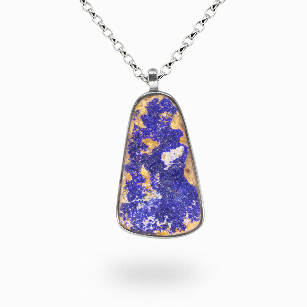 Raw azurite druzy pendant with deep blue crystal clusters and golden matrix set in a sterling silver bezel on a silver chain.