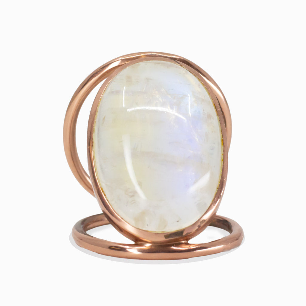 Oval cabochon Rainbow Moonstone ring with an open halo band in rose gold vermeil, showing blue and white iridescent sheen. | MADE IN EARTH