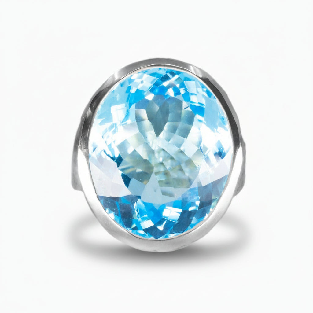 Faceted oval Blue Topaz ring in sterling silver, featuring a bright electric blue gemstone against a white background | MADE IN EARTH