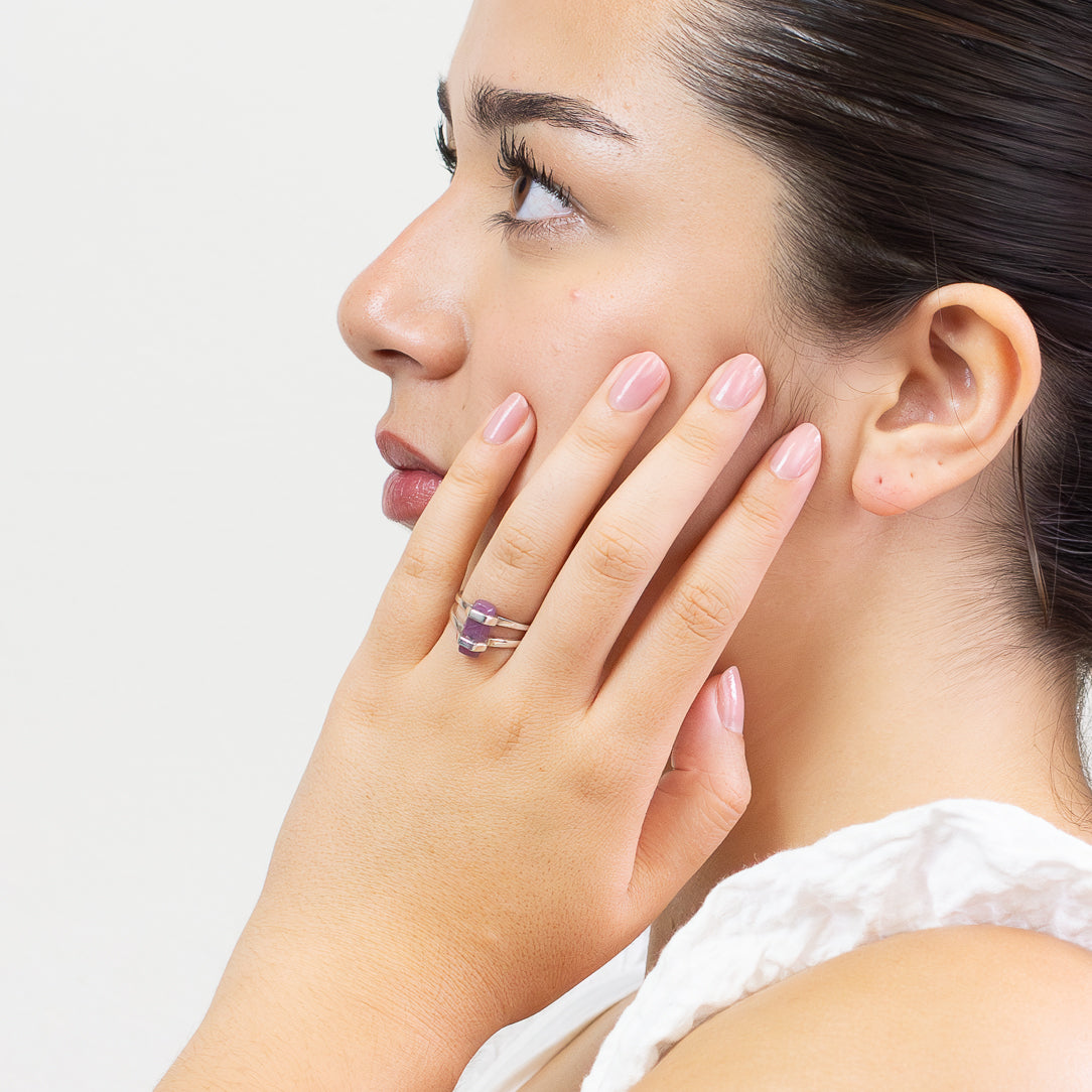 Raw pink-red Ruby pencil crystal ring set in sterling silver double-band design on a white background on model. MADE IN EARTH