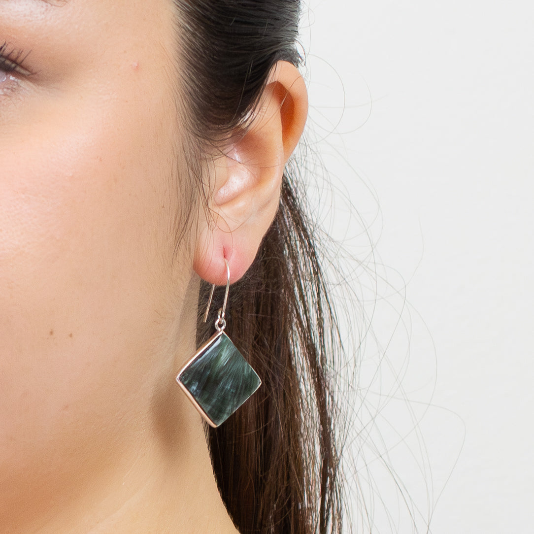 Diamond-shaped Seraphinite cabochon earrings in sterling silver with green and silver feather-like patterns. | MADE IN EARTH