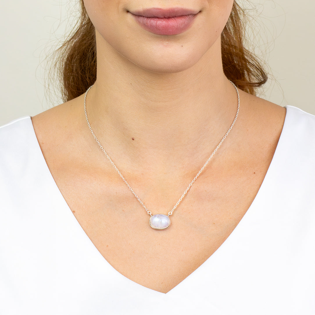 Rainbow Moonstone necklace in sterling silver featuring an oval cabochon with luminous blue iridescent flash.