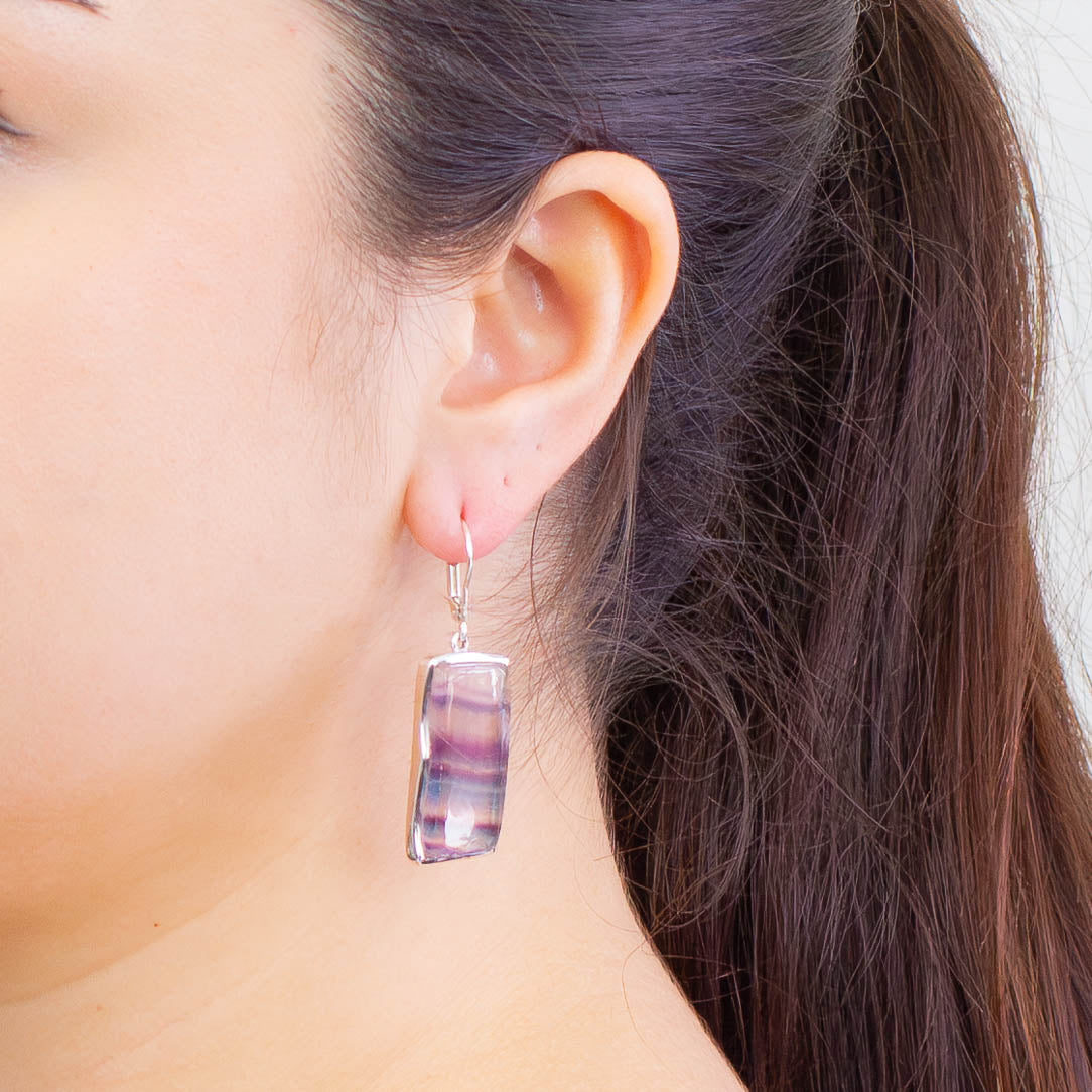 Fluorite rectangular cabochon bezel drop earrings in sterling silver with French clasp, showcasing blue, green, and purple tones on model | MADE IN EARTH