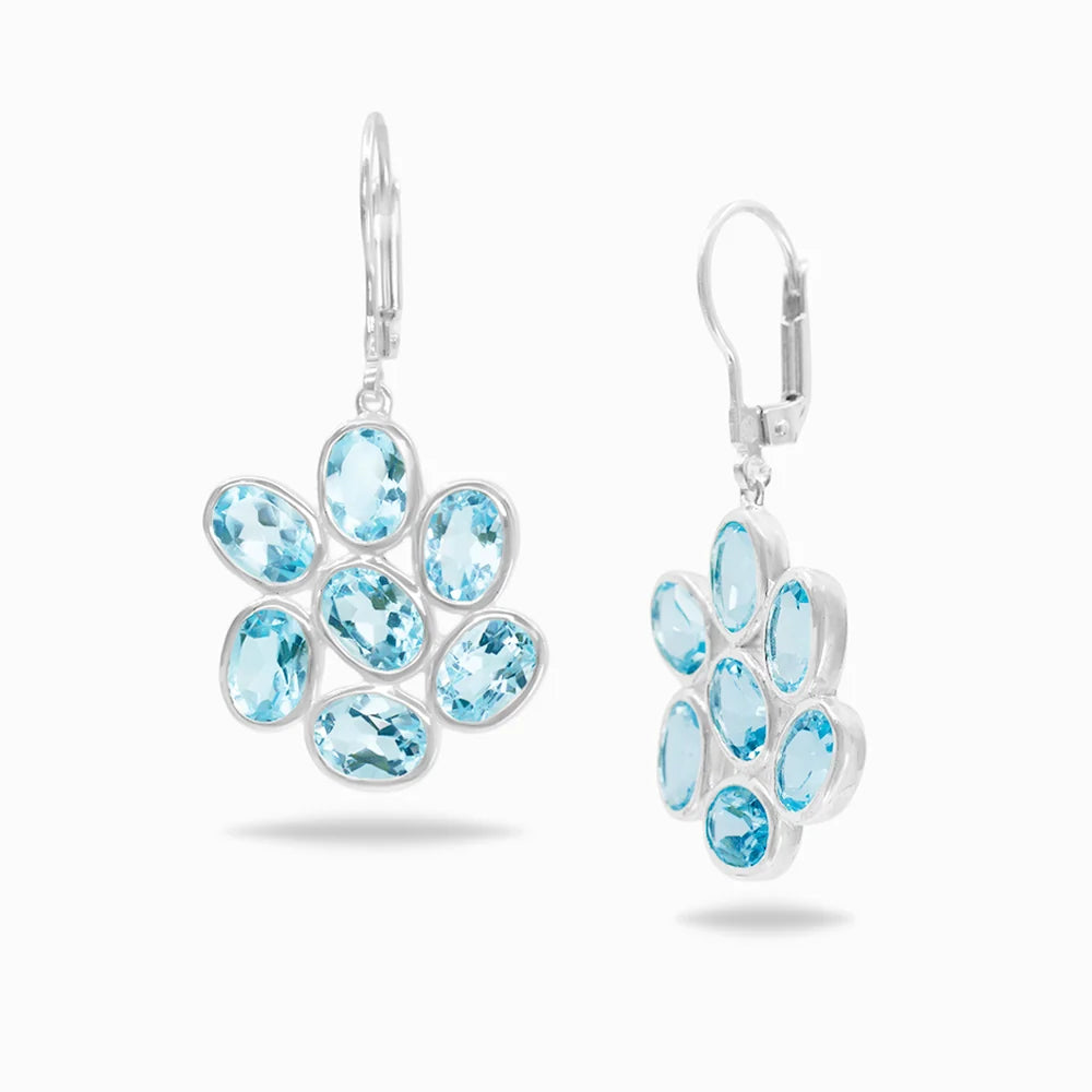 Faceted oval Blue Topaz gemstones bezel set in polished sterling silver cluster drop earrings.