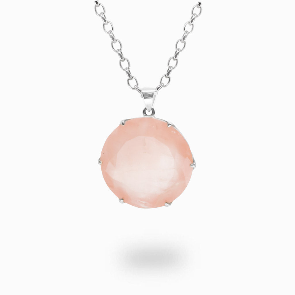 Faceted round Rose Quartz pendant necklace in a sterling silver claw setting featuring a soft blush-pink gemstone on a silver chain.