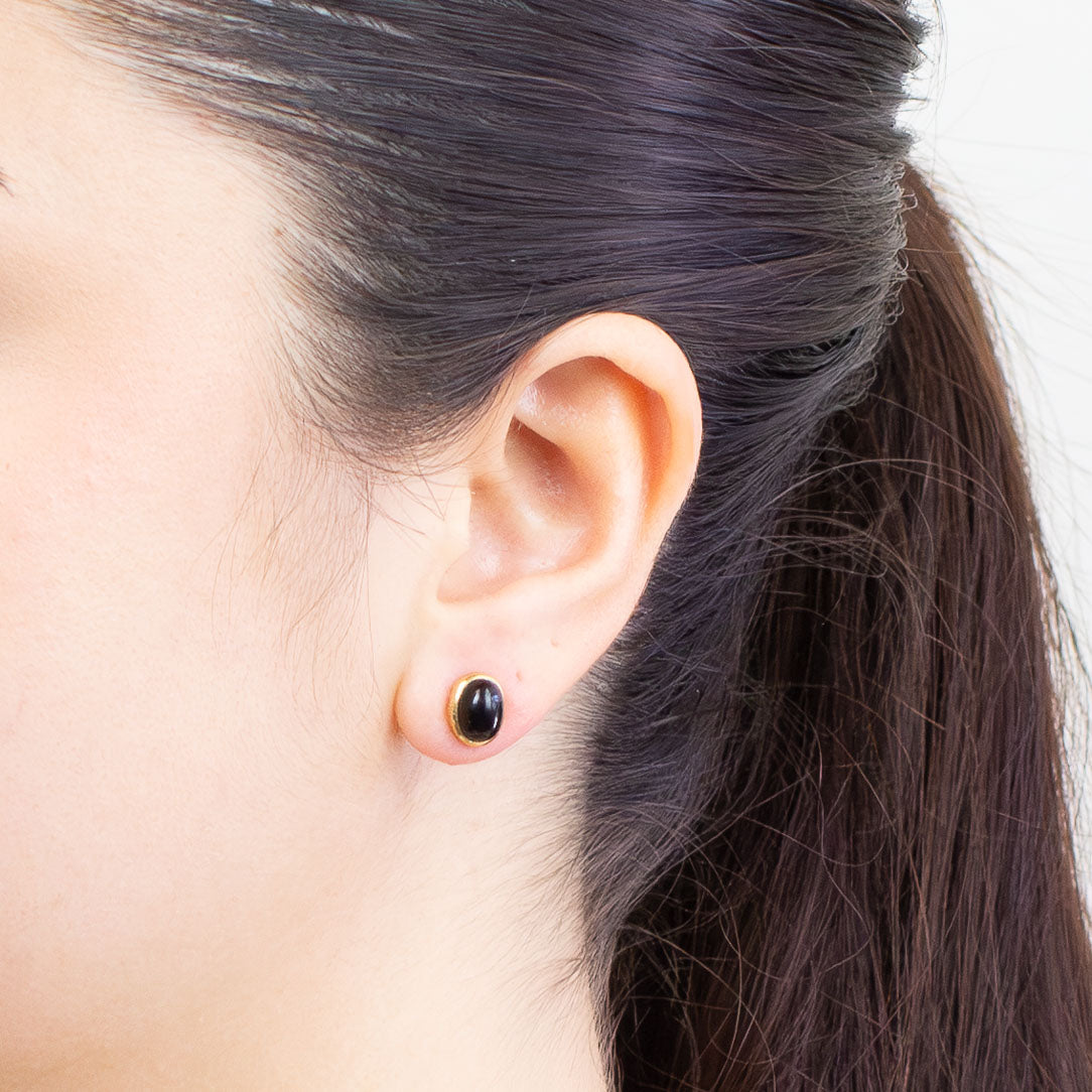 Pair of gold earrings with black onyx on a MODEL| MADE IN EARTH