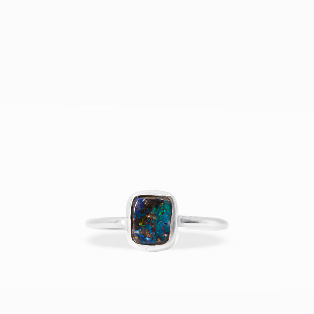 Rectangular Boulder Opal ring with electric blue and green flashes, natural brown ironstone matrix, and sterling silver bezel setting.