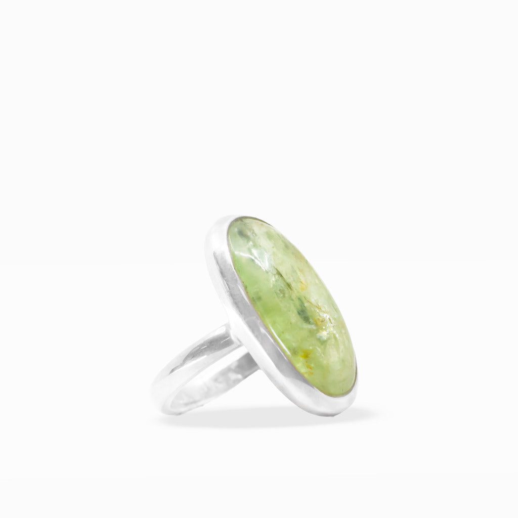Pale green translucent oval Green Kyanite cabochon ring with natural inclusions, sterling silver bezel, and split band.