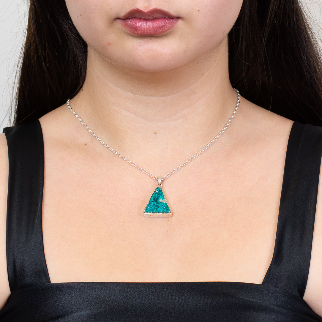 Raw green dioptase druzy triangle pendant in sterling silver bezel on model