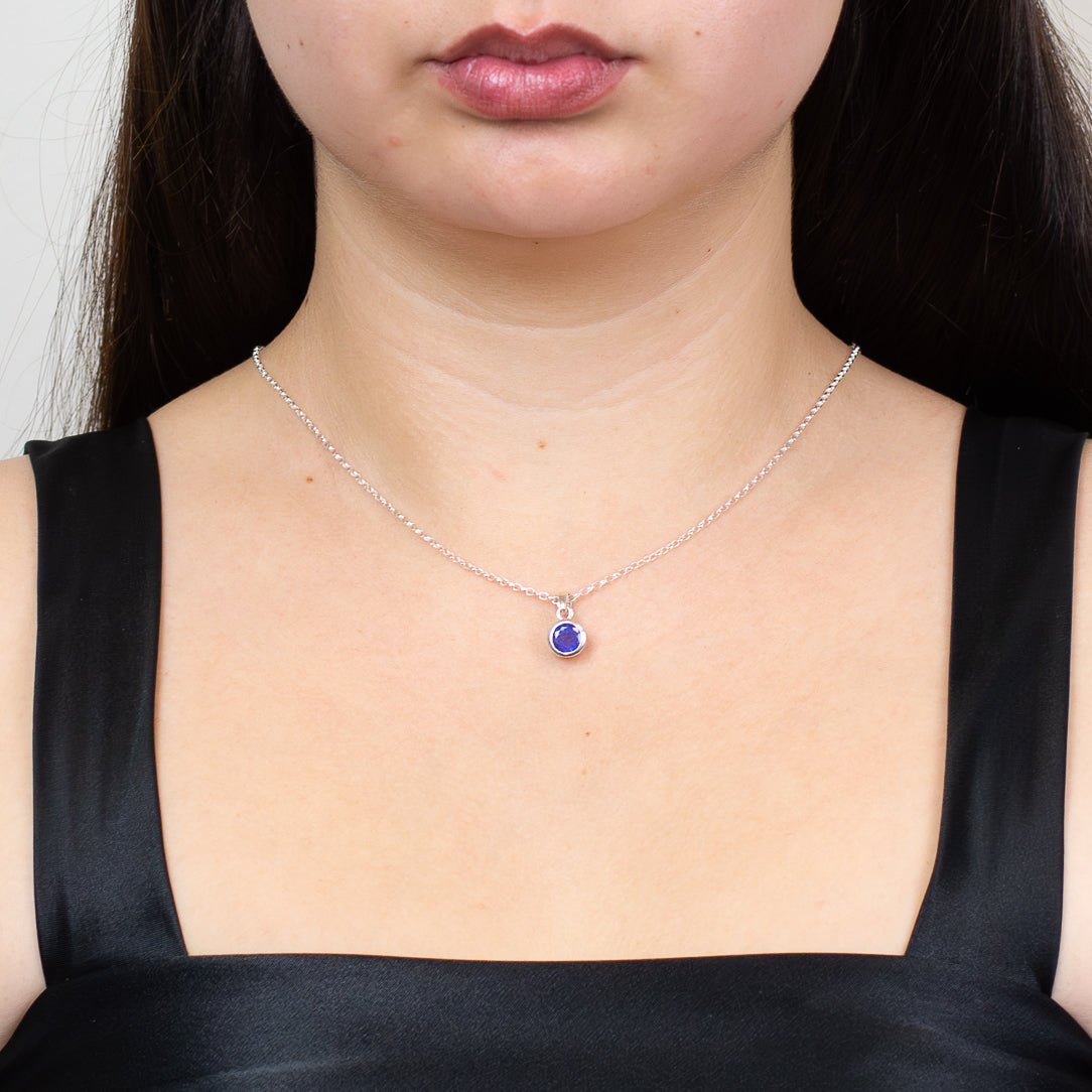 Faceted round tanzanite gemstone pendant set in sterling silver bezel.