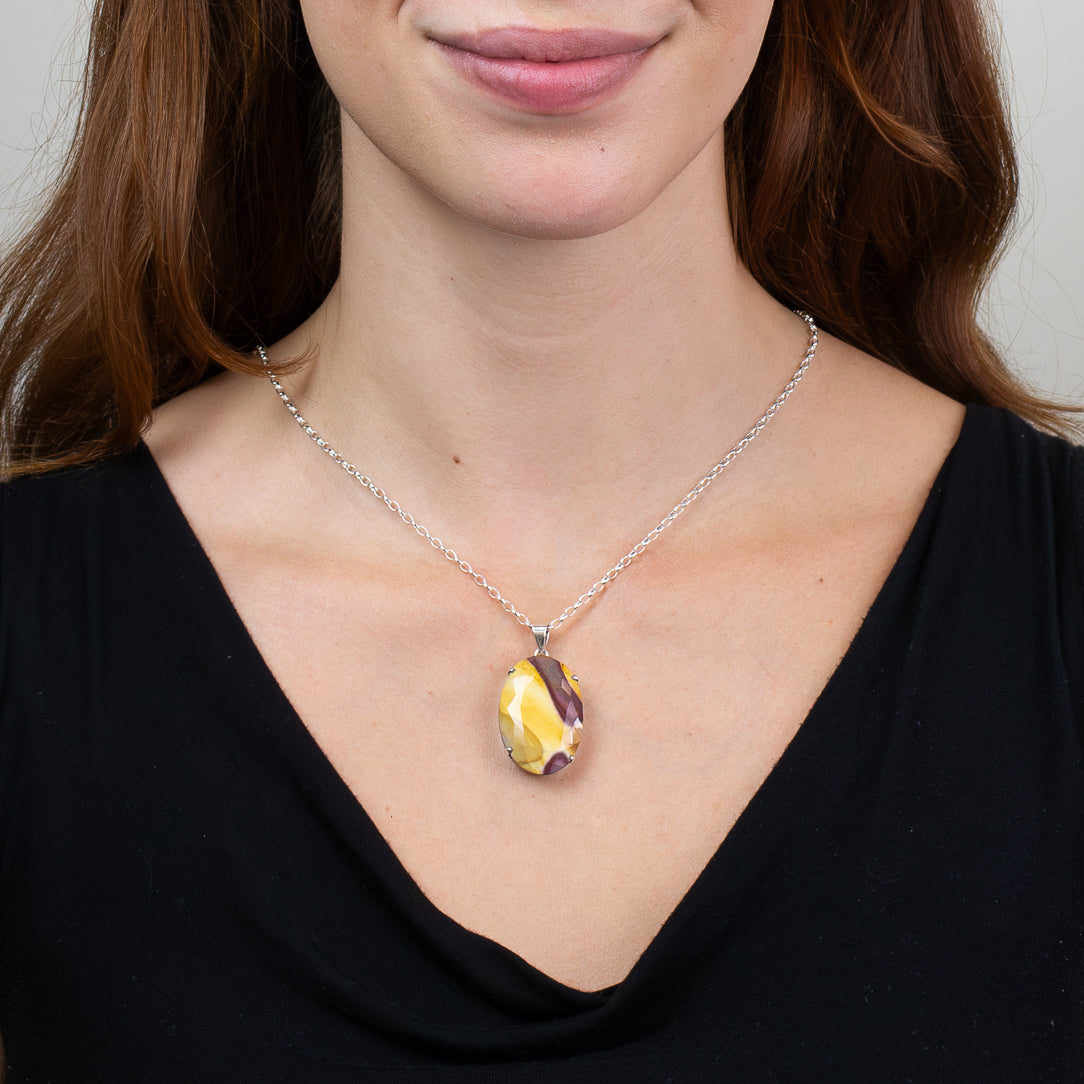 Faceted oval Mookaite pendant necklace in sterling silver featuring golden yellow and burgundy natural gemstone patterns. ON MODEL