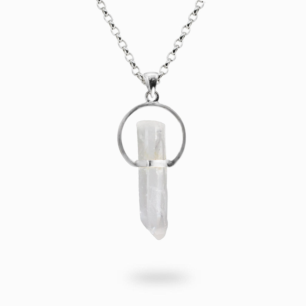 Natural raw Clear Quartz crystal point suspended vertically within an open circular sterling silver halo pendant.