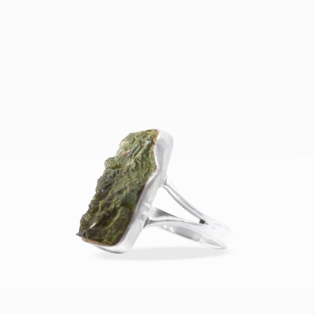 Translucent olive-green freeform Moldavite ring with textured natural surface, sterling silver bezel setting, and split band.