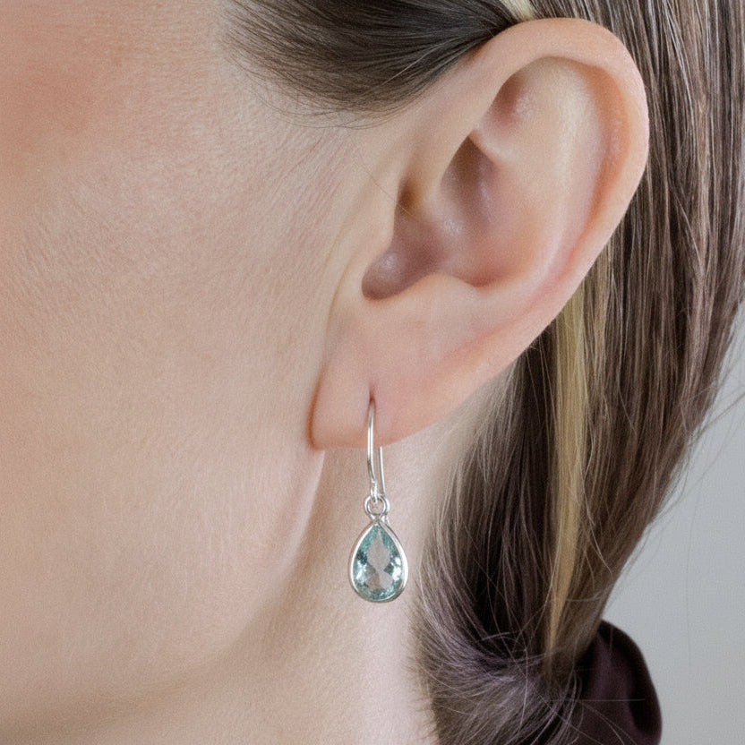 Teardrop faceted Blue Topaz gemstones bezel set in polished sterling silver drop earrings.