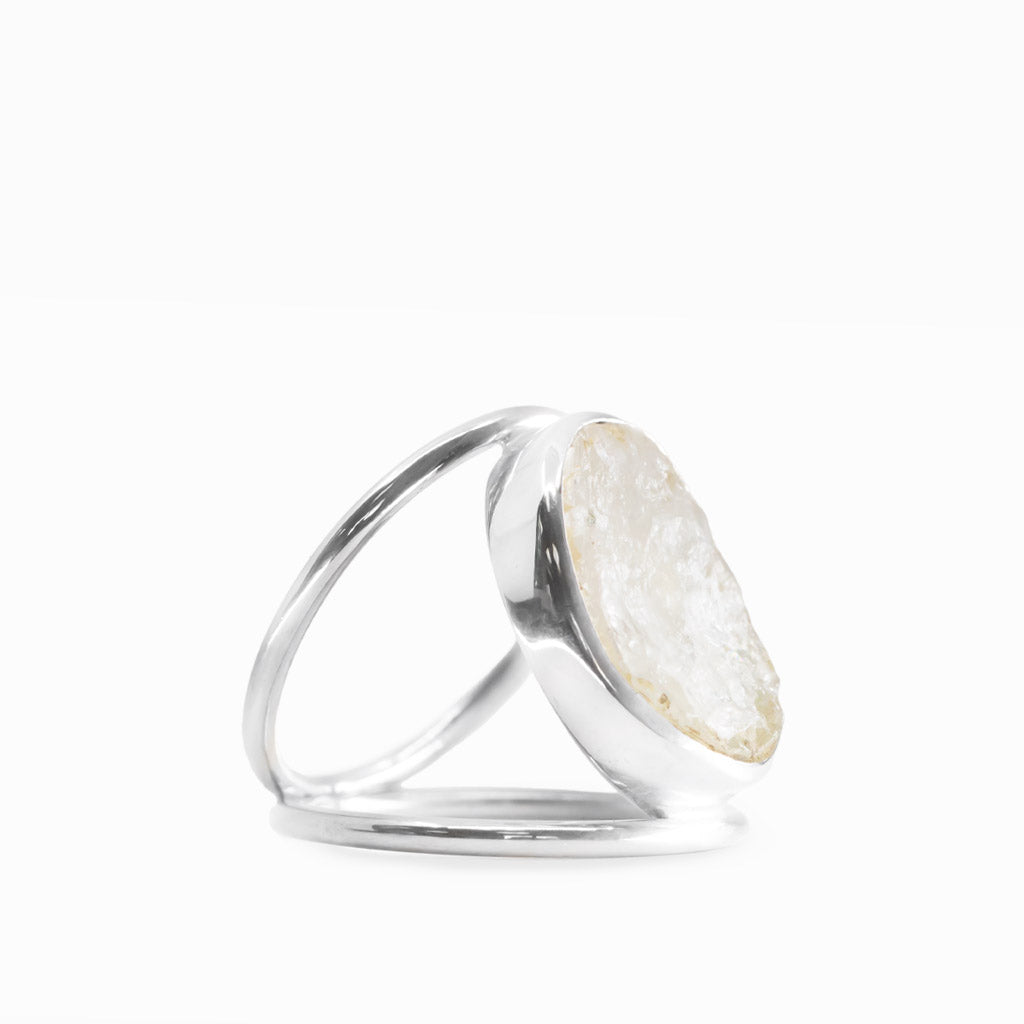 Oval Rainbow Moonstone ring with milky-white gemstone, subtle natural inclusions, polished sterling silver bezel, and openwork band.