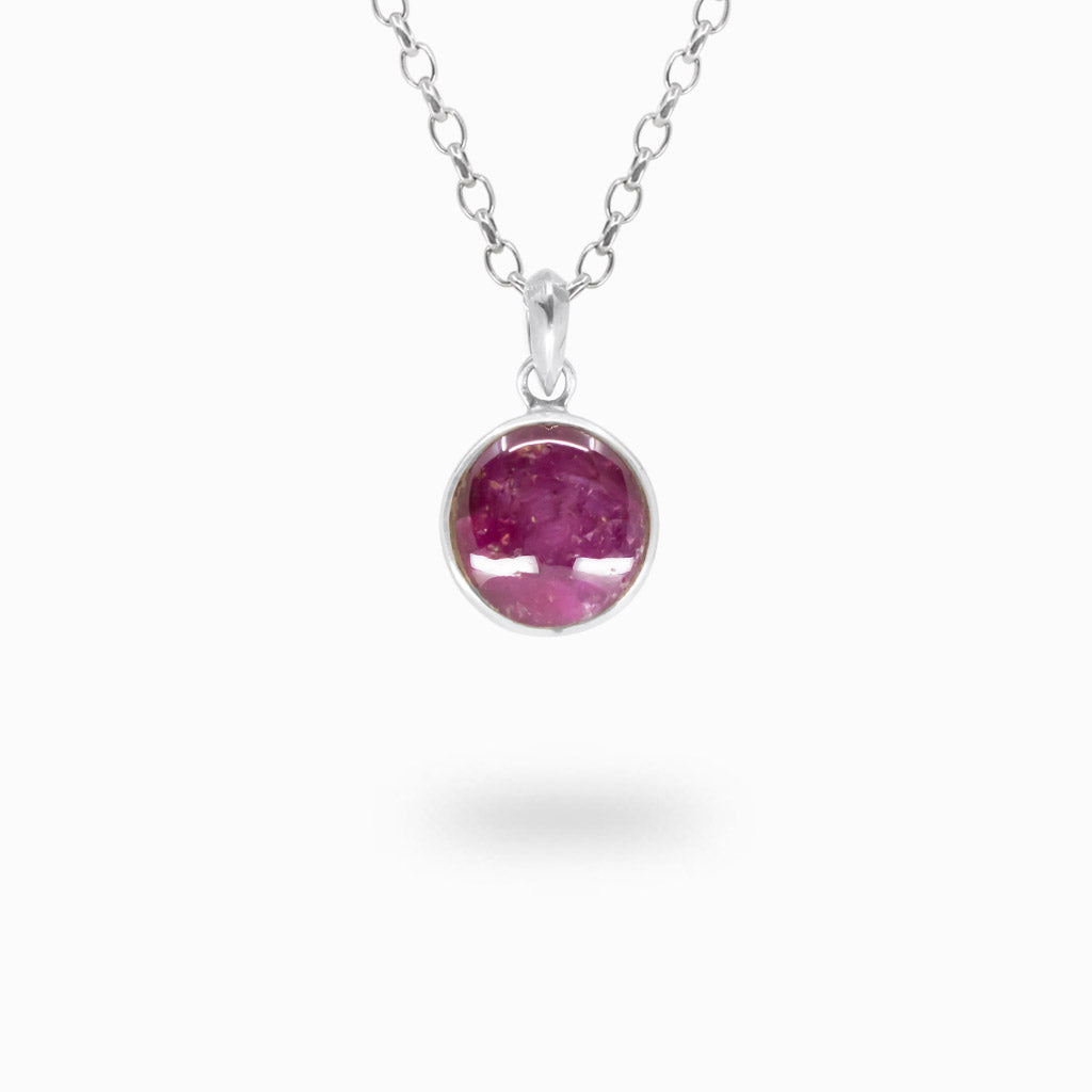 Round raspberry-red Star Ruby cabochon pendant with natural inclusions in a polished 925 sterling silver bezel setting.