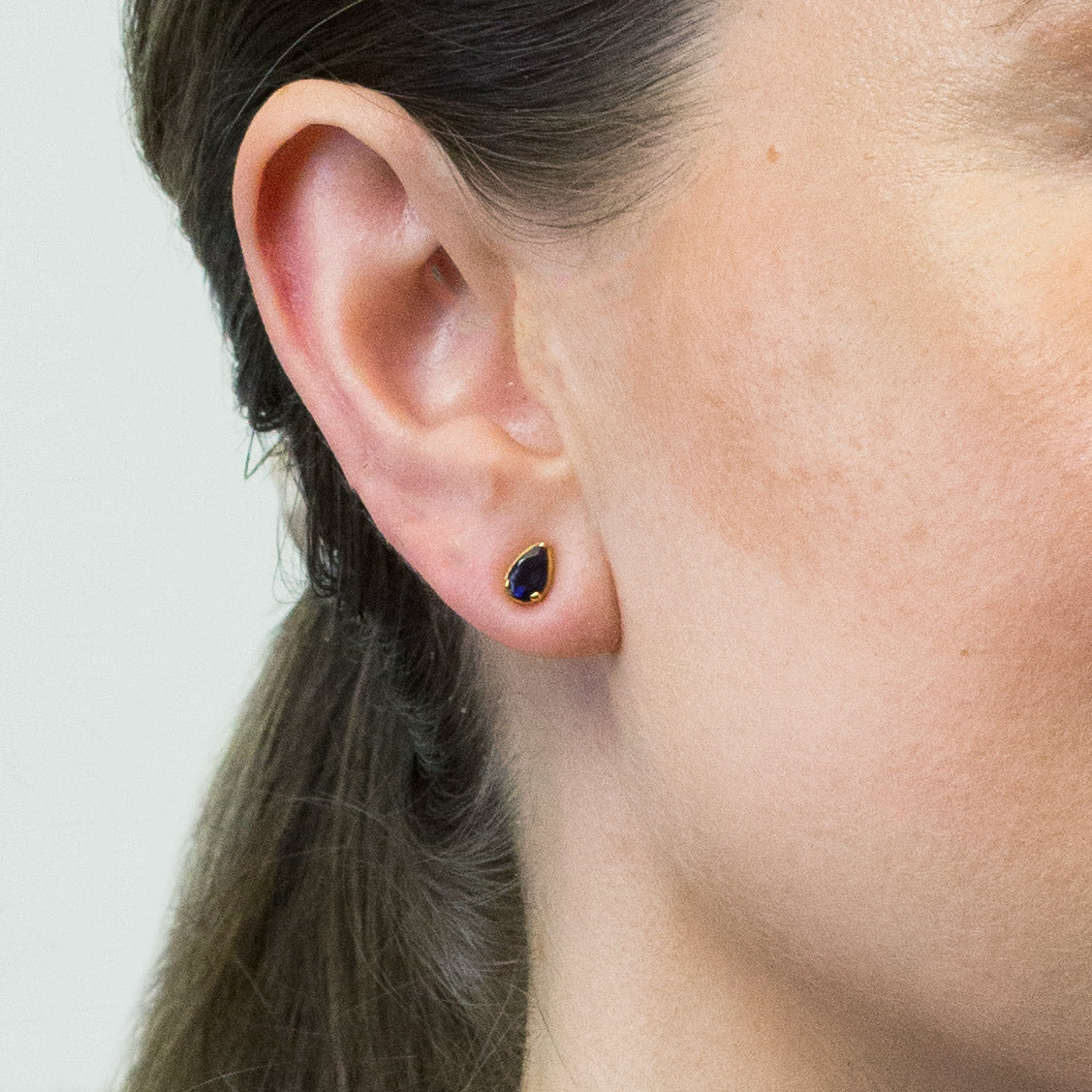 FACETED TEAR IOLITE STUD EARRINGS WITH GOLD VERMEIL FINISH ON MODEL