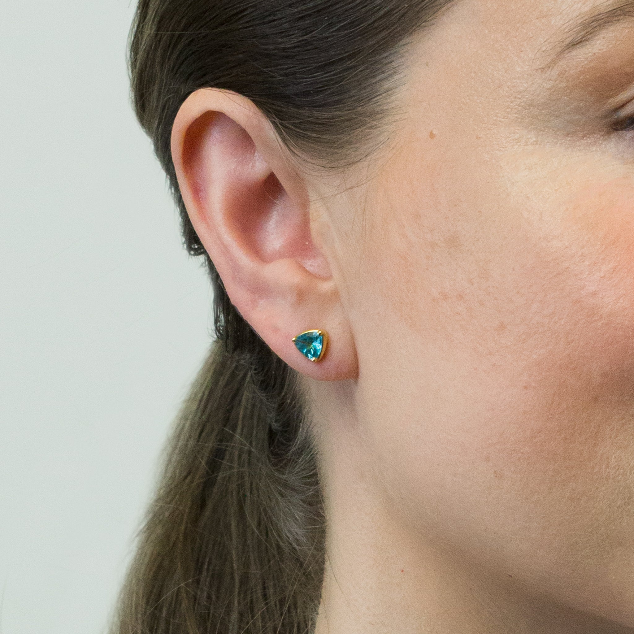 FACETED TRIANGLE APATITE STUD EARRINGS WITH GOLD VERMEIL FINISH ON MODEL