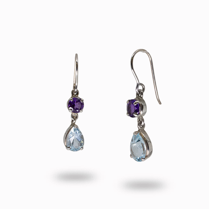 Pair of silver earrings with teardrop-shaped gemstones on a white background