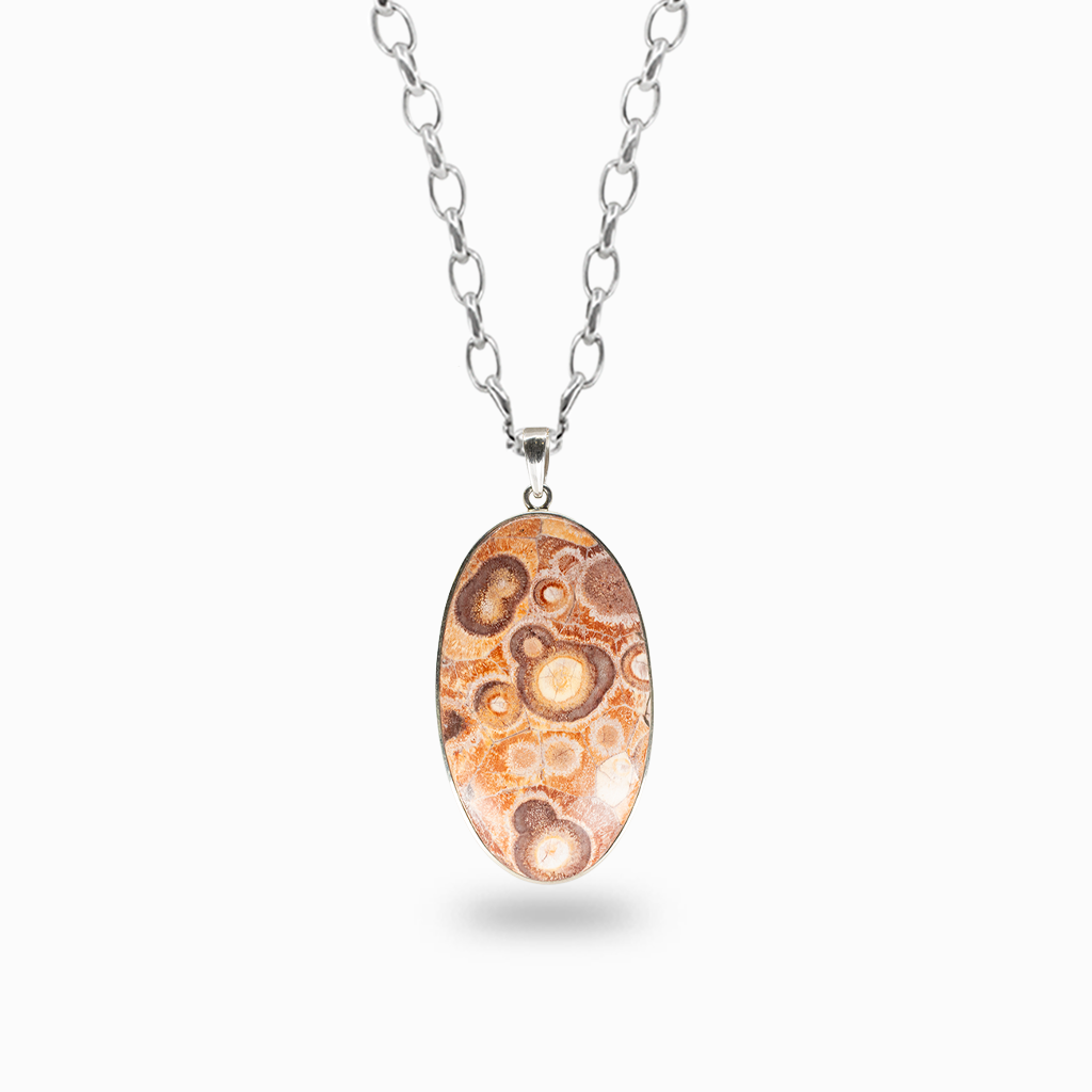 Oval Fossilized Coral pendant necklace with peach and brown circular fossil patterns, framed in polished sterling silver.