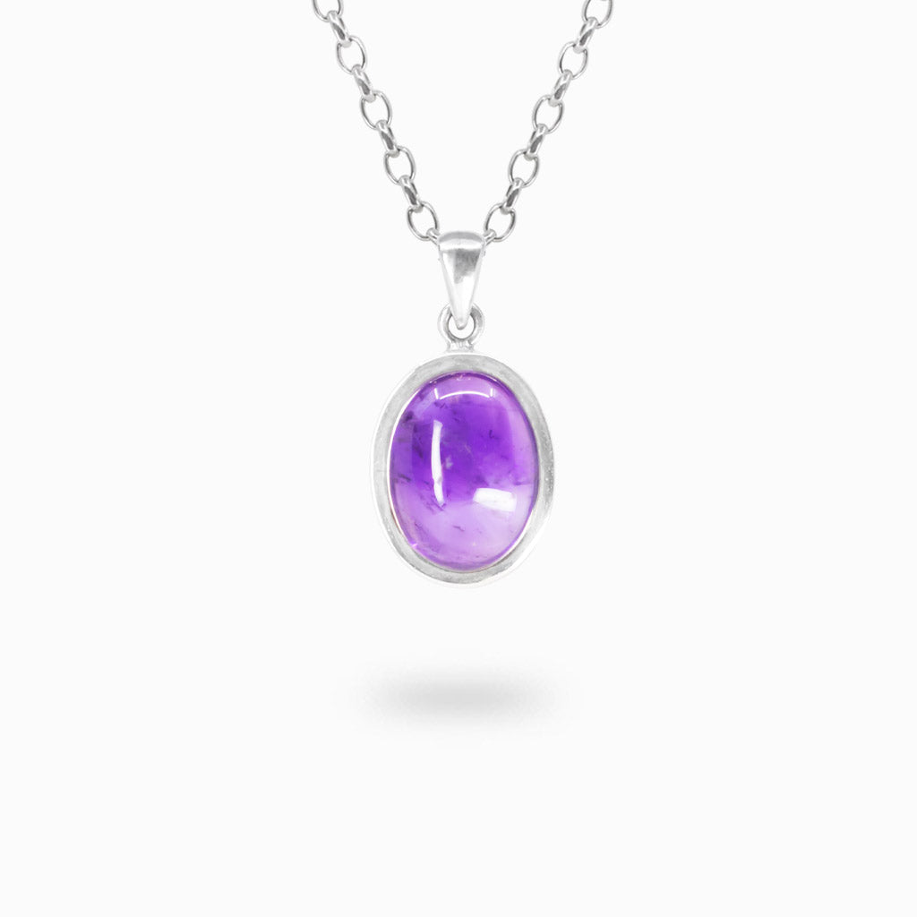 Oval purple Amethyst cabochon pendant with natural inclusions in a polished 925 sterling silver bezel setting.
