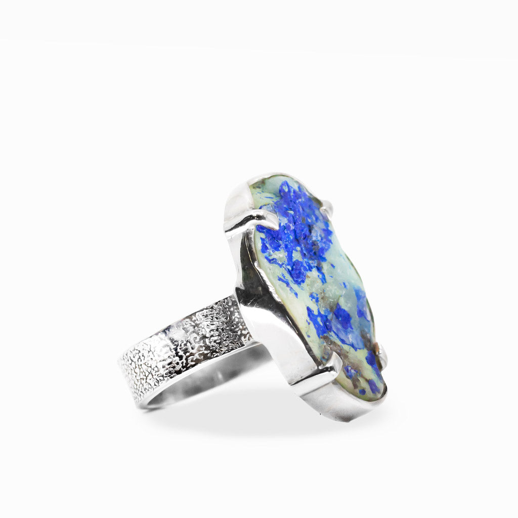 Oval Azurite Chrysocolla in Quartz ring with vivid electric-blue crystal clusters, pale green and white matrix, and sterling silver prongs.