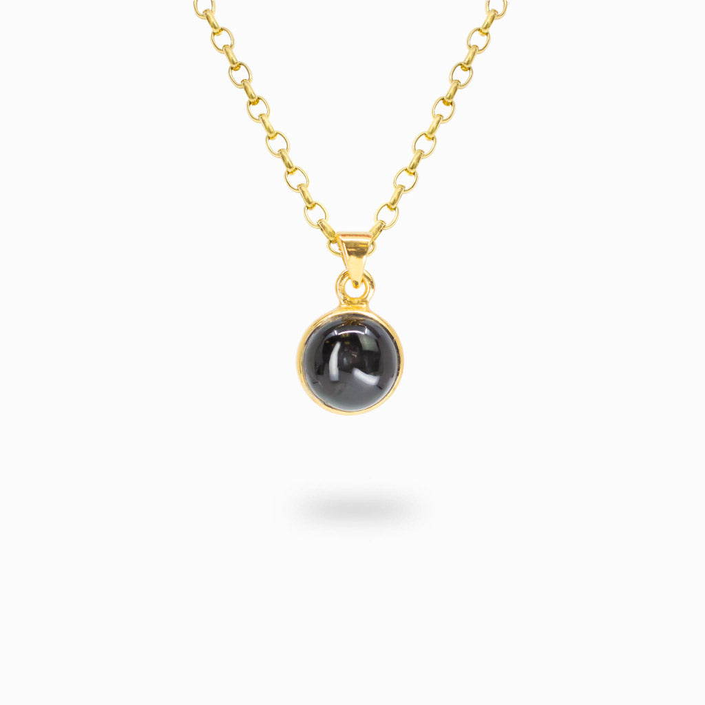 Round Black Star Diopside cabochon pendant set in polished 14K gold vermeil over sterling silver.