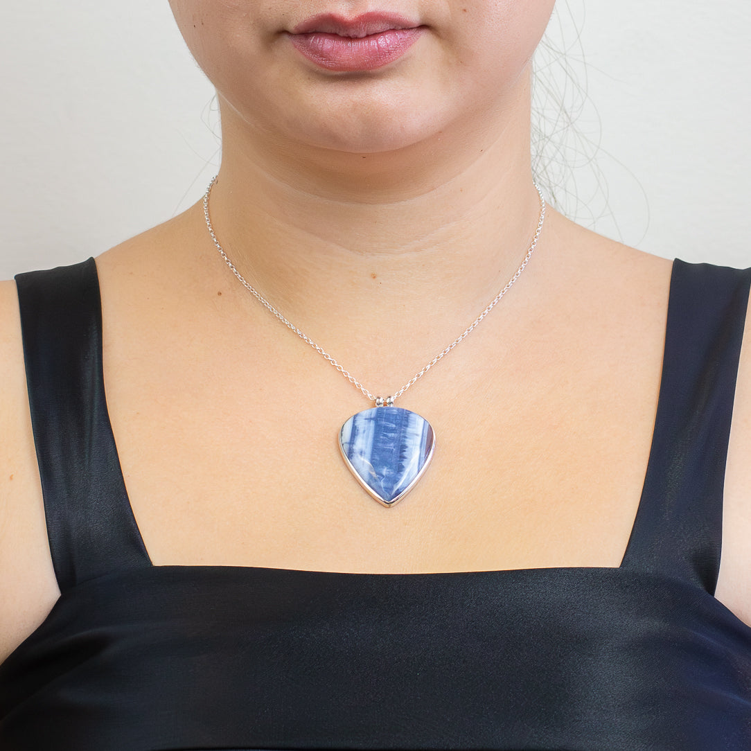 Teardrop-shaped Blue Opal pendant with soft blue and white banding set in polished sterling silver on a chain.| MADE IN EARTH