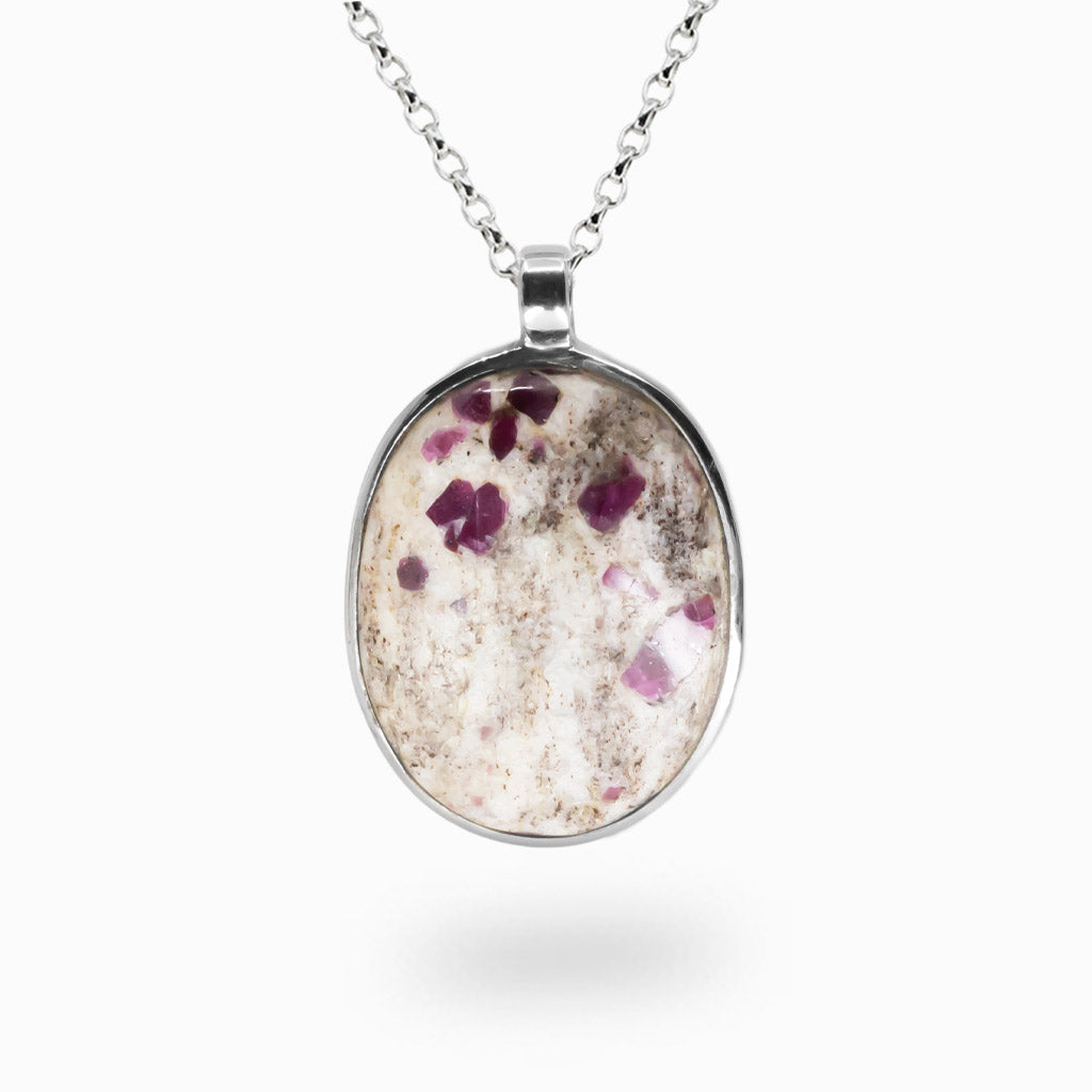 Oval Ruby in Matrix pendant featuring deep crimson ruby crystals within a pale marbled stone, set in polished sterling silver on a chain. | MADE IN EARTH