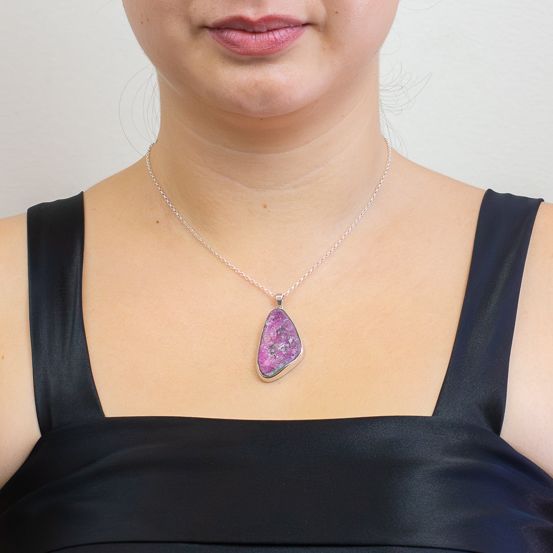 Organic raw Ruby pendant featuring vivid magenta-red crystal formations set in polished sterling silver on a chain. | MADE IN EARTH