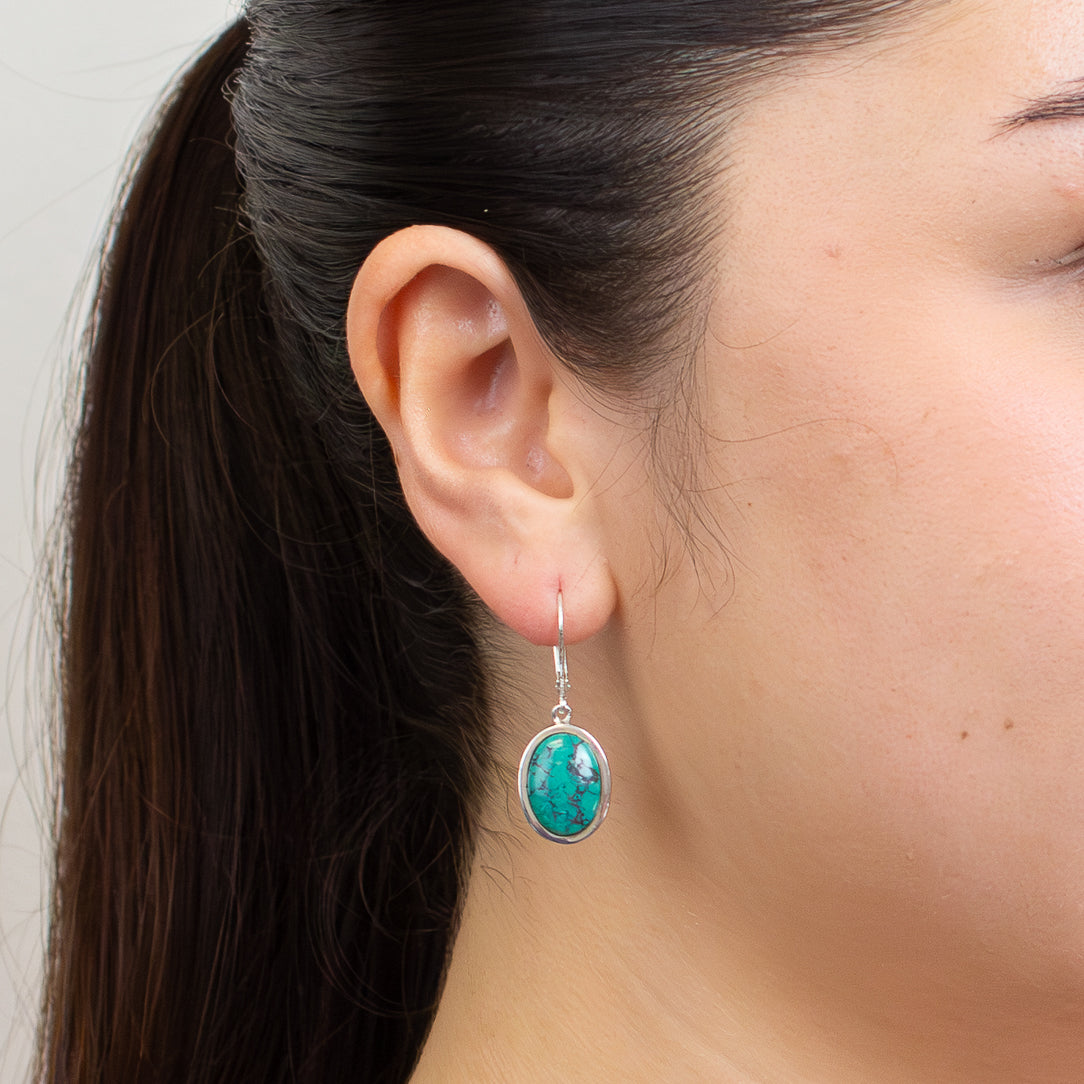 Tibetan turquoise cabochon drop earrings with blue-green stones and black matrix in sterling silver.