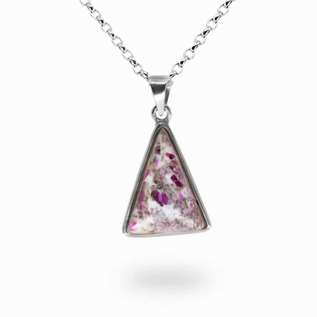 Triangular ruby in matrix pendant with a pink and white speckled design on a silver chain against a white background