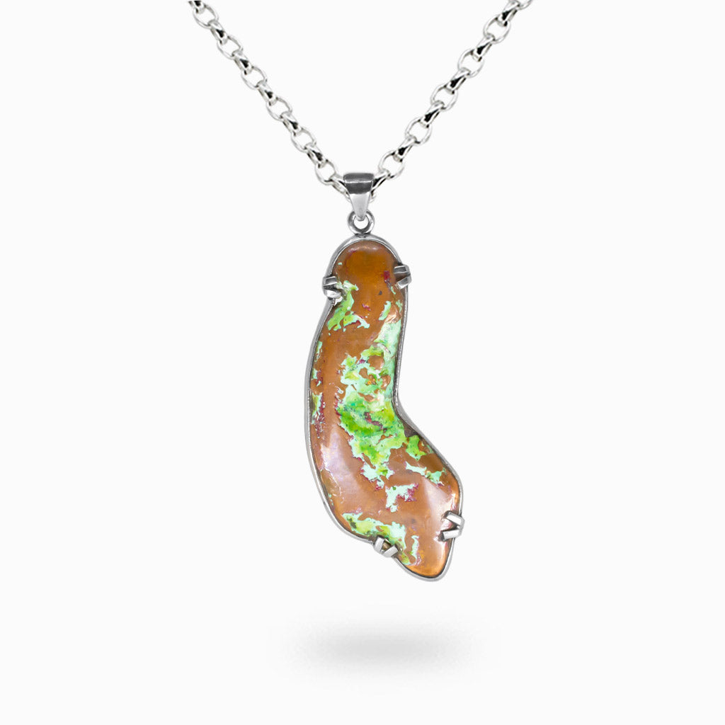 Freeform raw copper nugget pendant with green oxidized highlights set in sterling silver bezel on a silver chain.