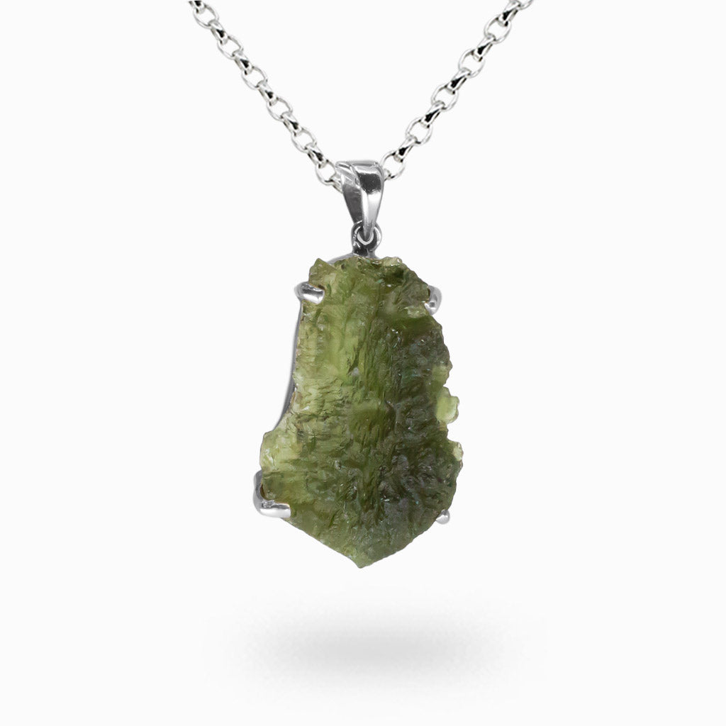 Raw green Moldavite crystal pendant with natural textured surface set in sterling silver prongs on a silver chain.