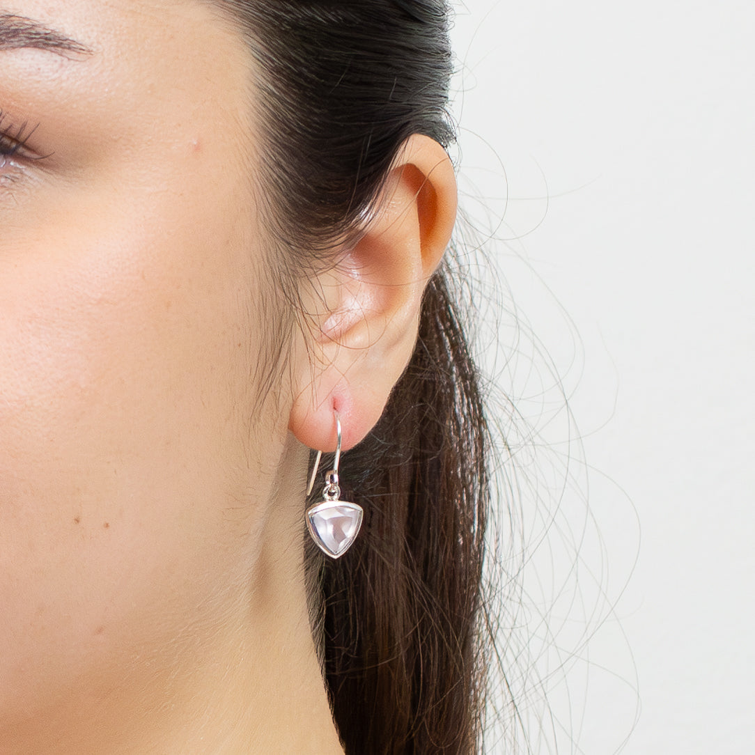 Faceted trillion-cut Rose Quartz drop earrings set in sterling silver with hook fittings ON MODEL |MADE IN EARTH