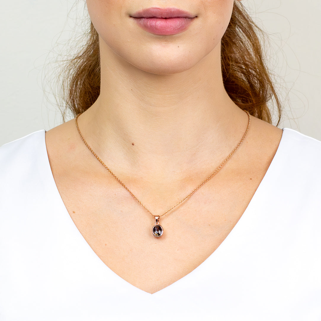 Rose gold necklace with a pendant worn by a person