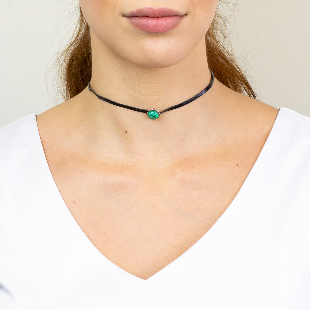 Malachite leather necklace featuring a polished green banded gemstone set in sterling silver on black cord.
