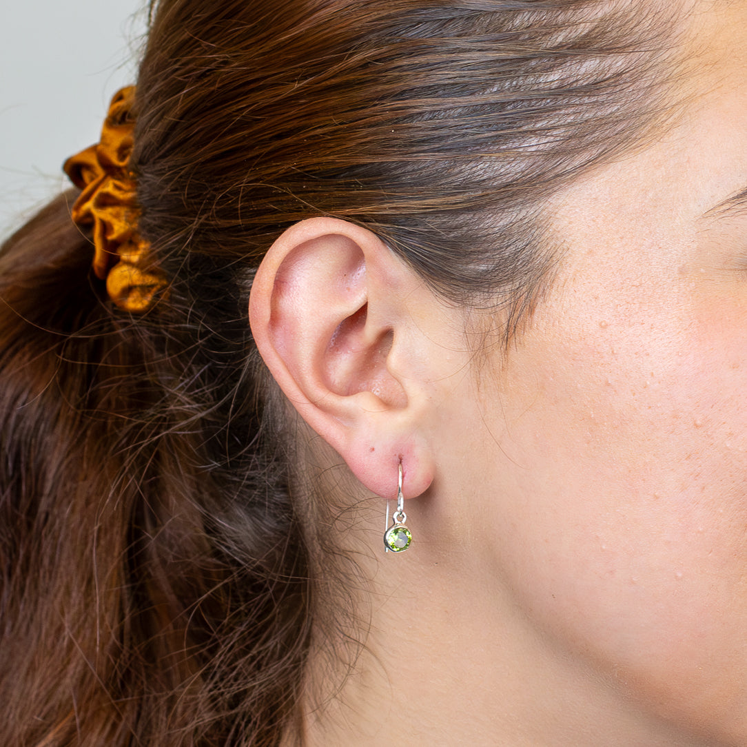 Faceted round peridot drop earrings in sterling silver ON MODEL