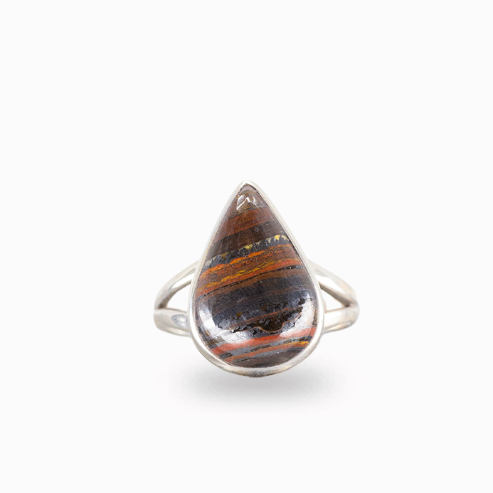 Pear-shaped Tiger Iron ring with layered rust-red, golden, and dark metallic bands, polished sterling silver bezel, and openwork band.