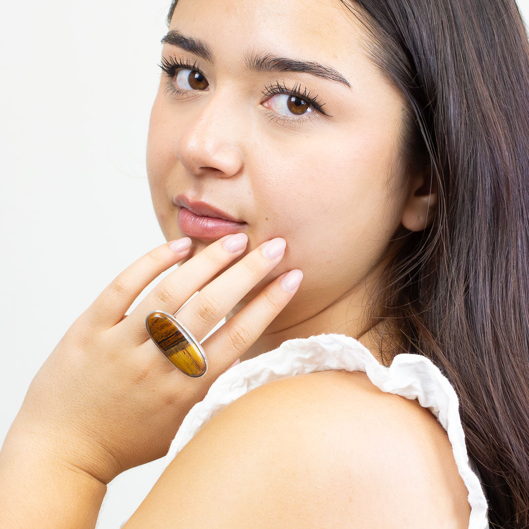 Oval tiger iron cabochon ring set in sterling silver bezel with layered red, gold, and brown tones