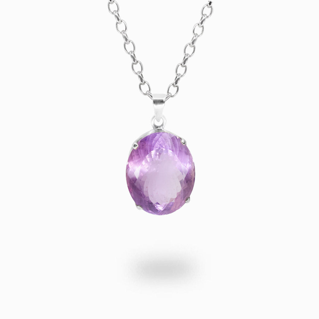 Faceted oval Amethyst pendant necklace in sterling silver featuring a vibrant purple gemstone suspended from a silver chain.