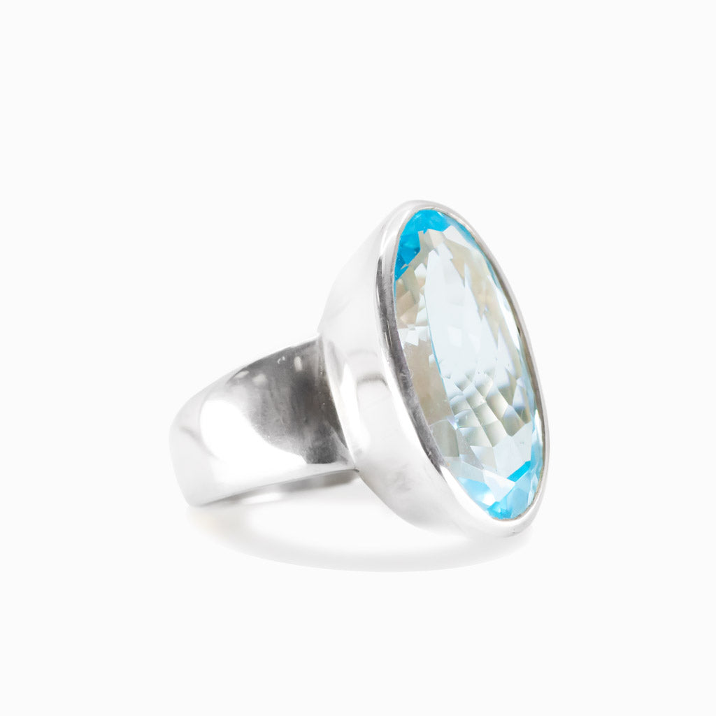 Faceted blue topaz oval ring in sterling silver with bright blue gemstone