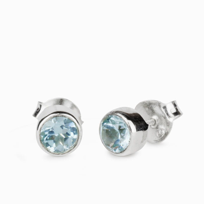 Round faceted Blue Topaz gemstones bezel set in polished sterling silver stud earrings.